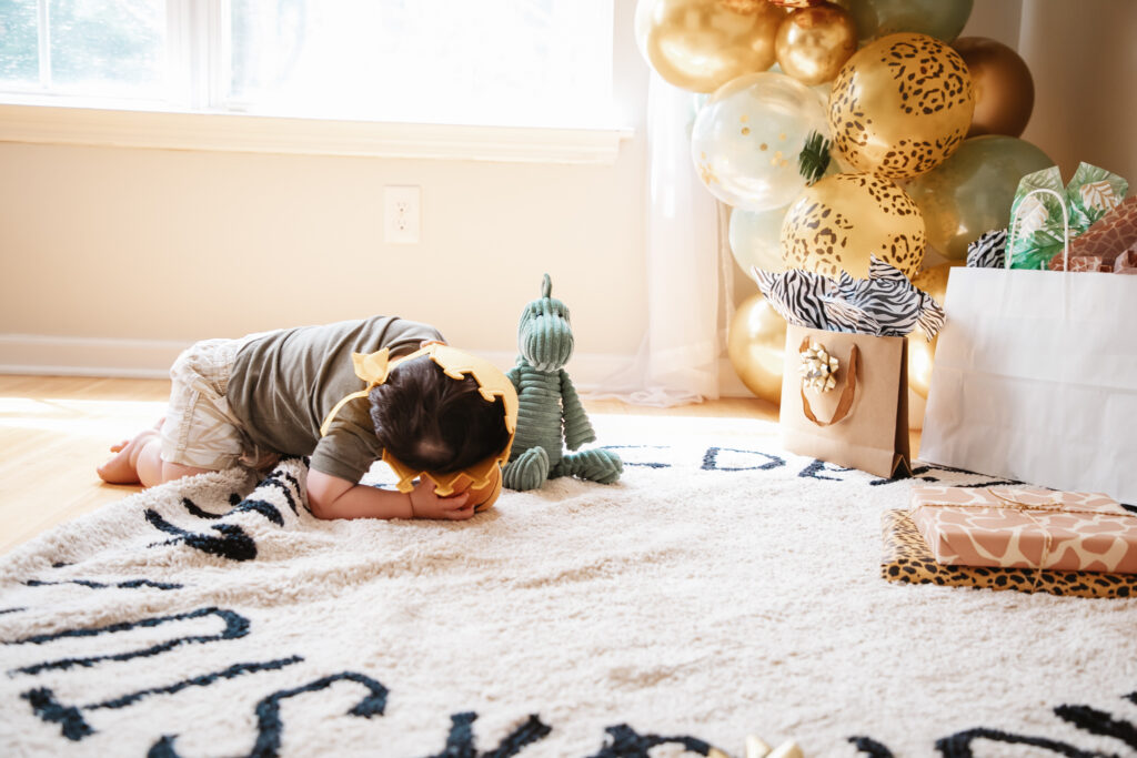 Luca is One! Wild One First Birthday Party - All the details of Luca's Wild One Safari Themed First Birthday. Wild One balloon backdrop and wild one tee. Safari balloon garland. First birthday crown. Alphabet rug.