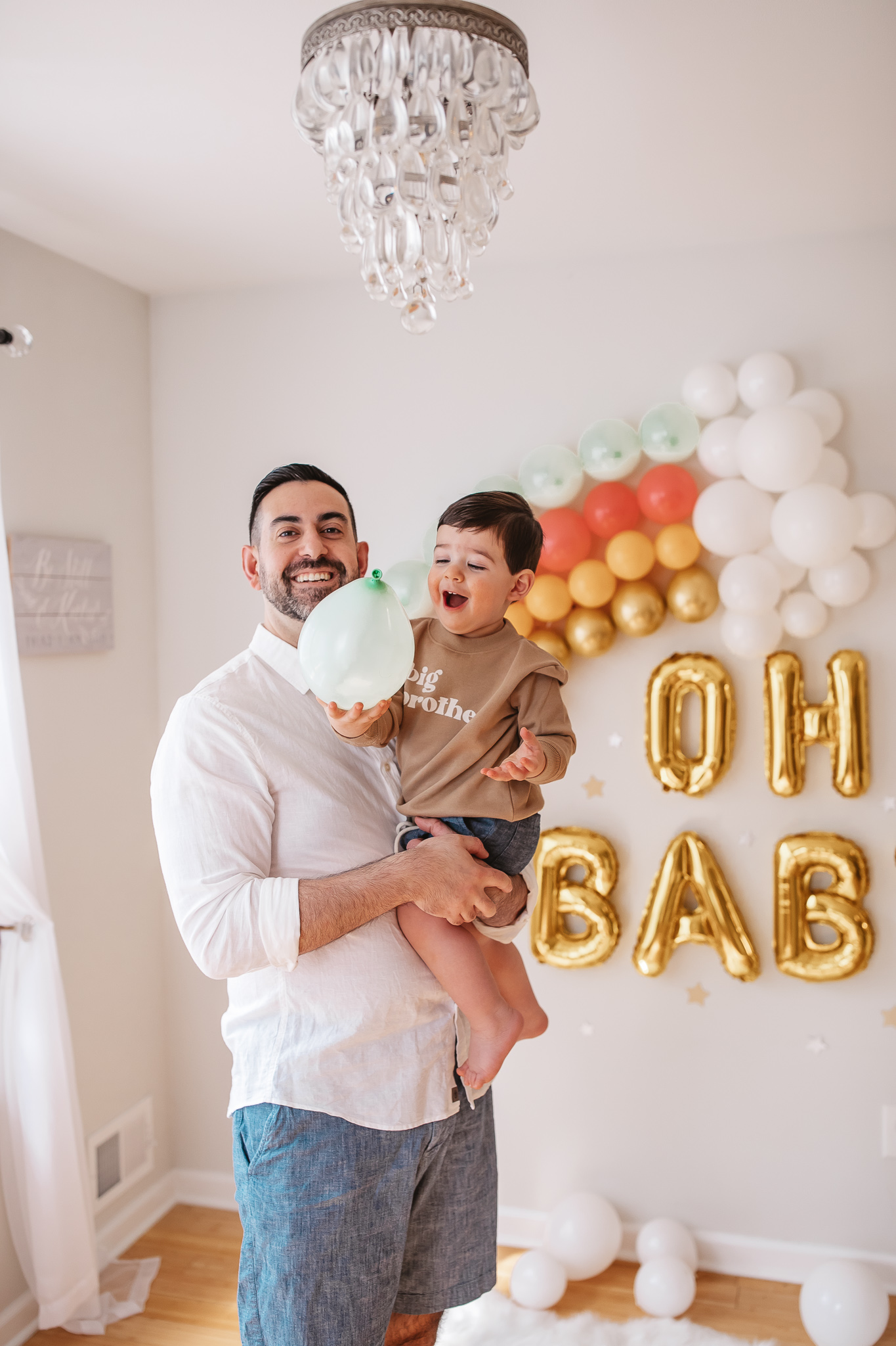 DIY Rainbow Baby Pregnancy Announcement. Rainbow baby balloon backdrop for photos.