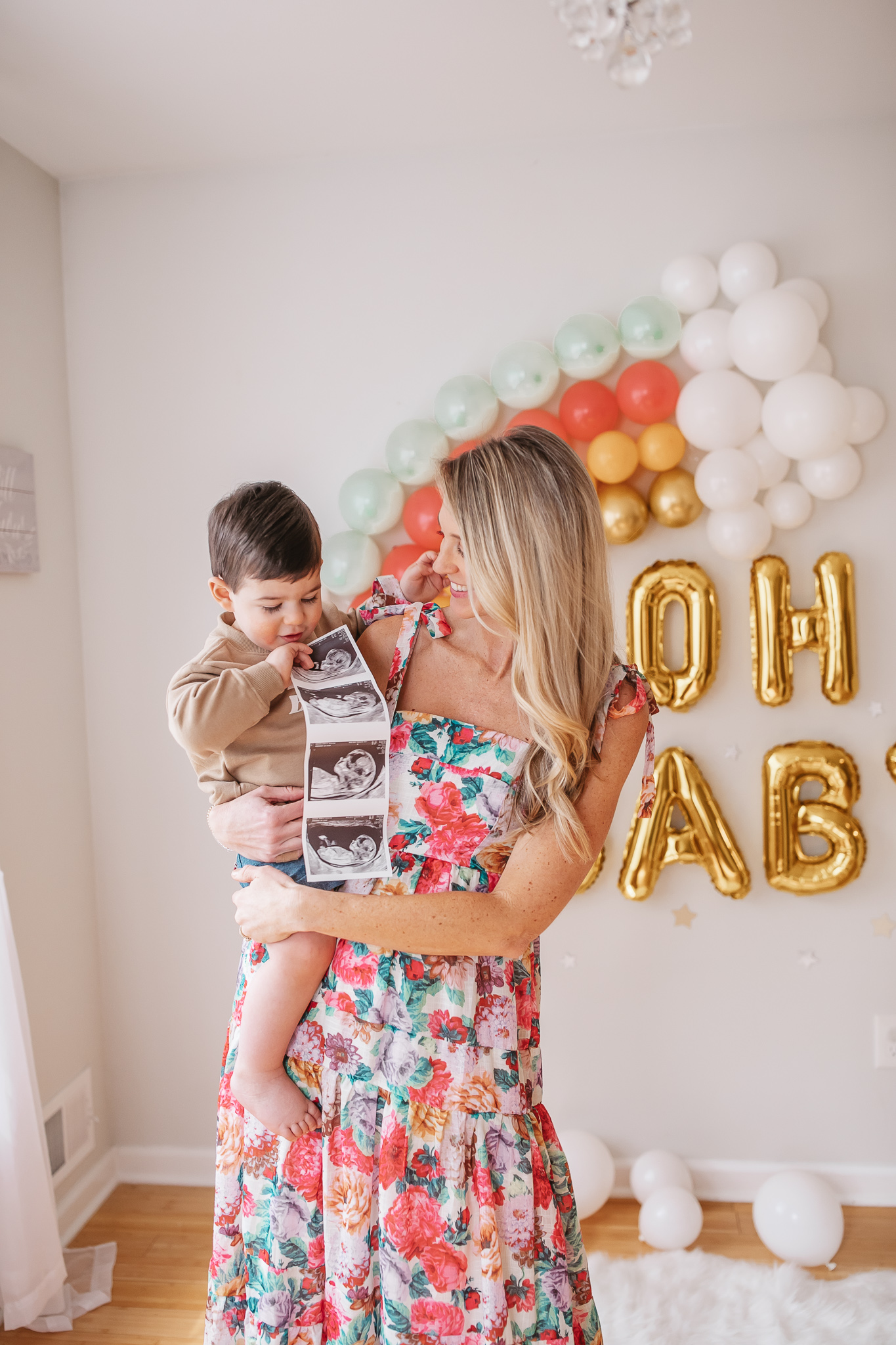DIY Rainbow Baby Pregnancy Announcement. Mommy to be and big brother with the ultrasound. Rainbow baby balloon backdrop for photos.