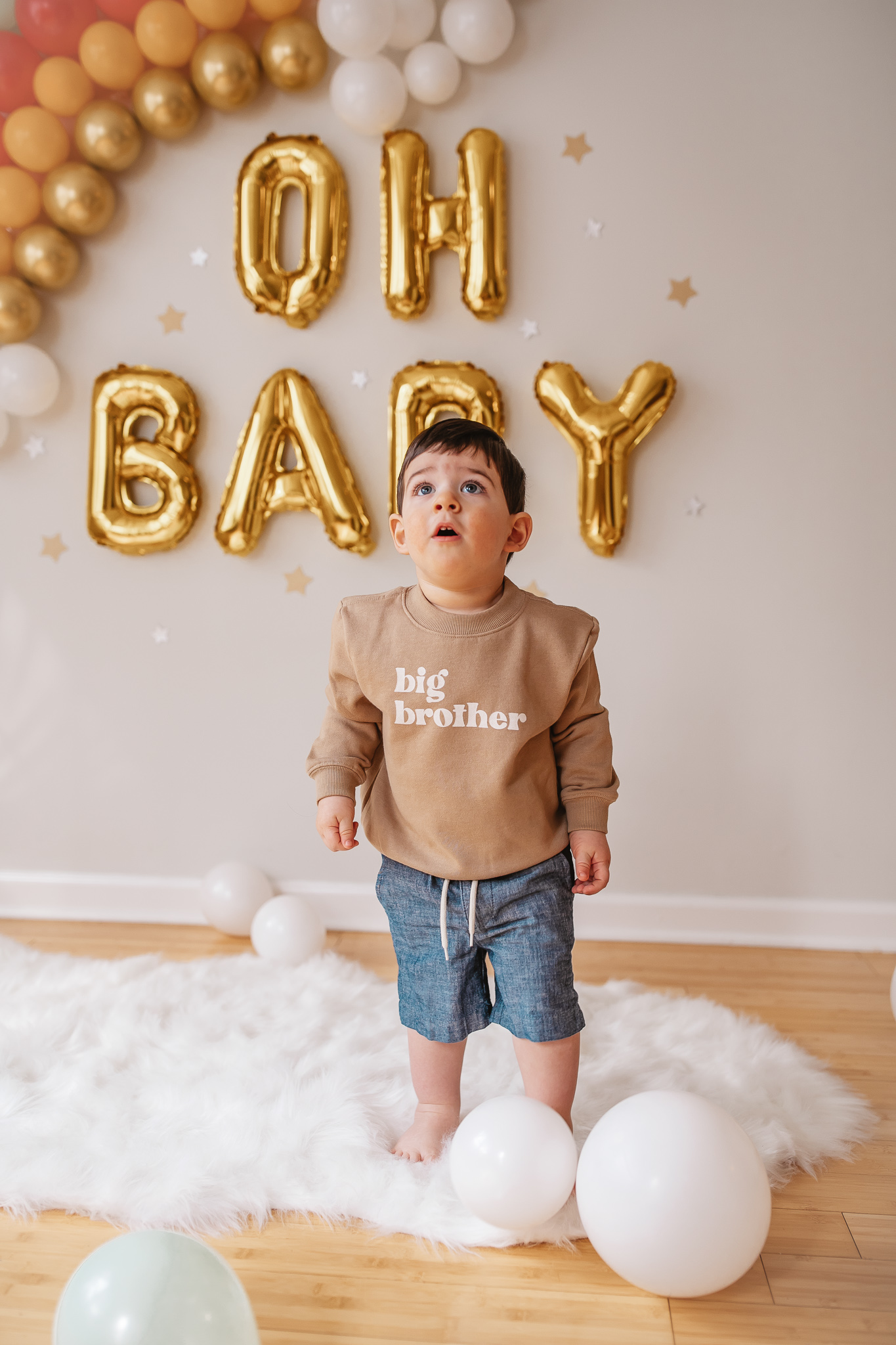 DIY Rainbow Baby Pregnancy Announcement. Big brother sweatshirt for toddlers. Rainbow baby balloon backdrop for photos.