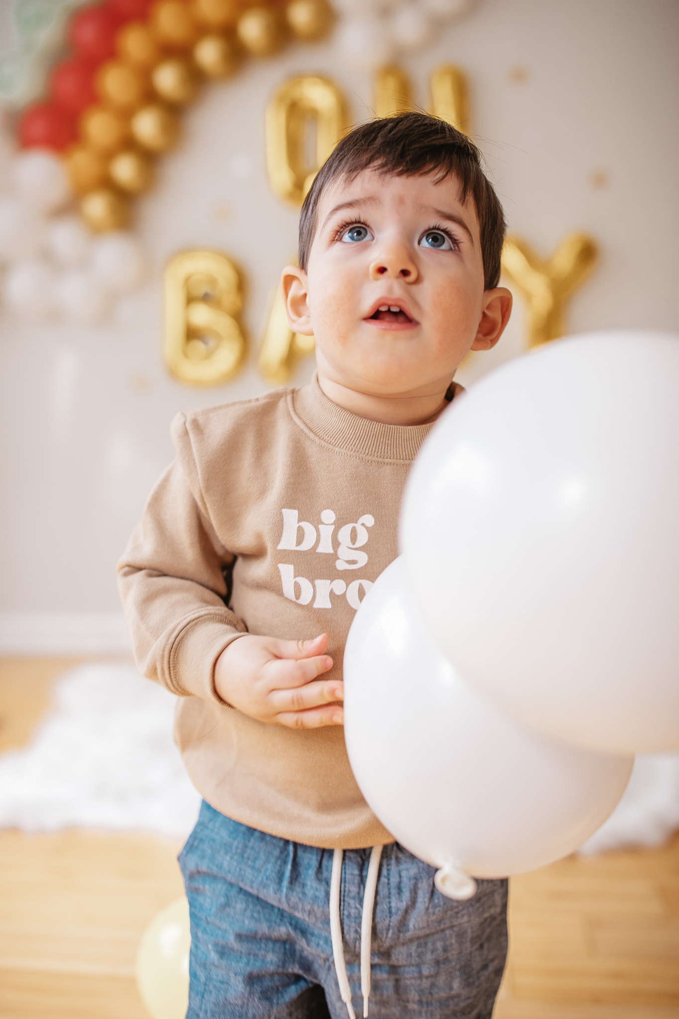 DIY Rainbow Baby Pregnancy Announcement. Big brother sweatshirt for toddlers. Rainbow baby balloon backdrop for photos.