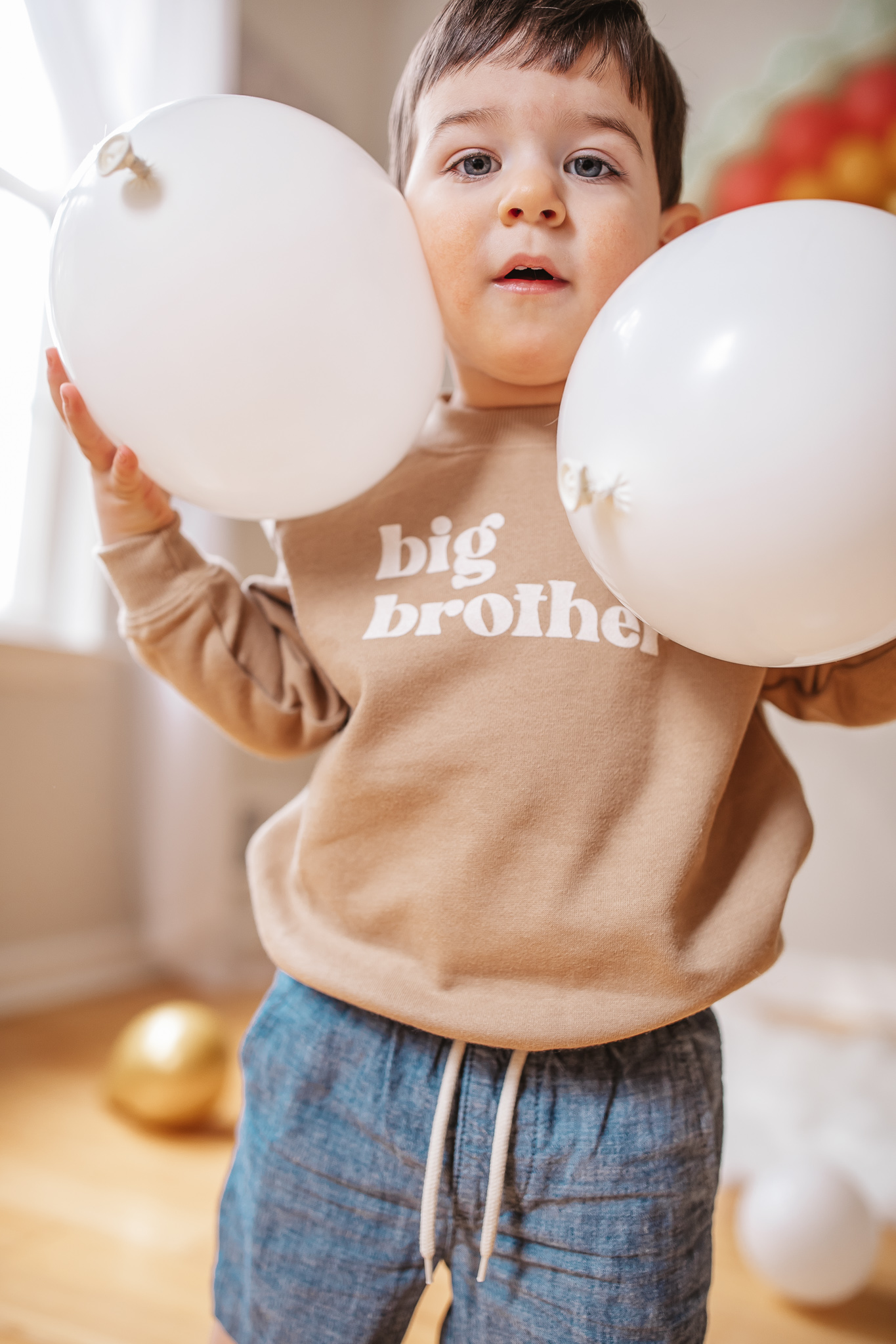 DIY Rainbow Baby Pregnancy Announcement. Big brother sweatshirt. Rainbow baby balloon backdrop for photos.