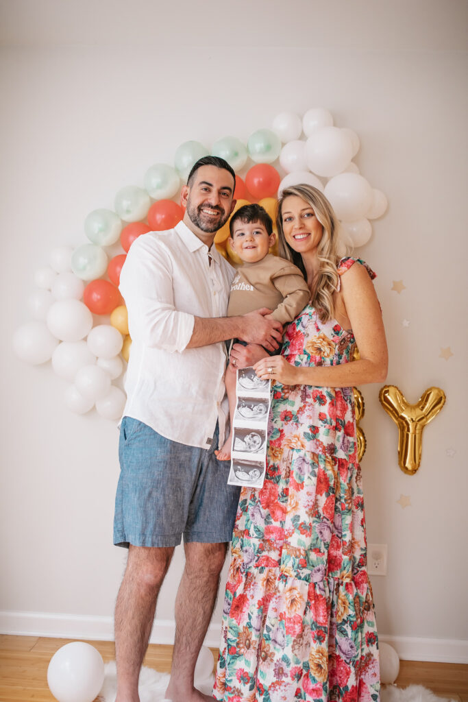 DIY Rainbow Baby Pregnancy Announcement. Rainbow balloon wall pregnancy announcement. Rainbow baby balloon backdrop for photos. Big brother sweatshirt.