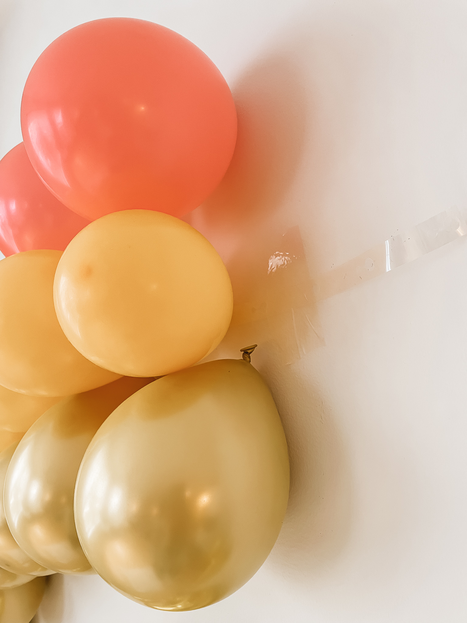 DIY Rainbow Baby Pregnancy Announcement. How to create a rainbow balloon wall for a pregnancy announcement. Rainbow baby balloon backdrop for photos.