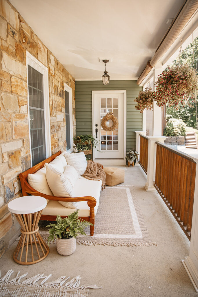 Neutral Front Porch Decor - Create a Front Porch Oasis. Hanging porch swing and oversized outdoor sofa. Hanging planters. Outdoor pillows. Natural materials and greenery.