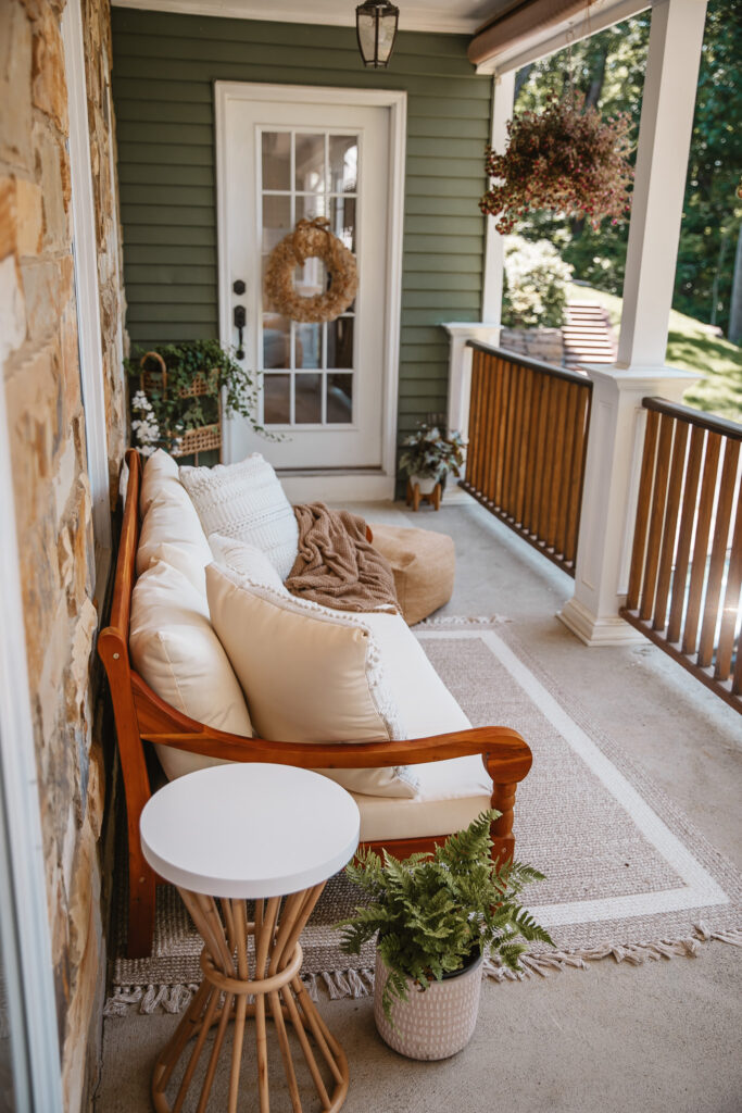 Neutral Front Porch Decor - Create a Front Porch Oasis. Hanging porch swing and oversized outdoor sofa. Hanging planters. Outdoor pillows. Natural materials and greenery.