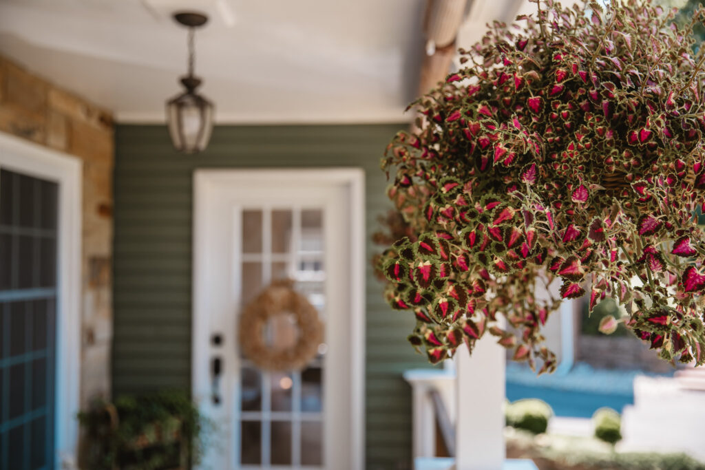 Neutral Front Porch Decor - Create a Front Porch Oasis. Hanging porch swing and oversized outdoor sofa. Hanging planters. Outdoor pillows. Natural materials and greenery.