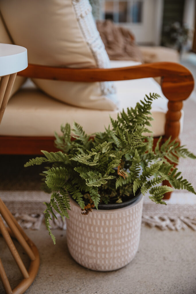 Neutral Front Porch Decor - Create a Front Porch Oasis. Hanging porch swing and oversized outdoor sofa. Hanging planters. Outdoor pillows. Natural materials and greenery.